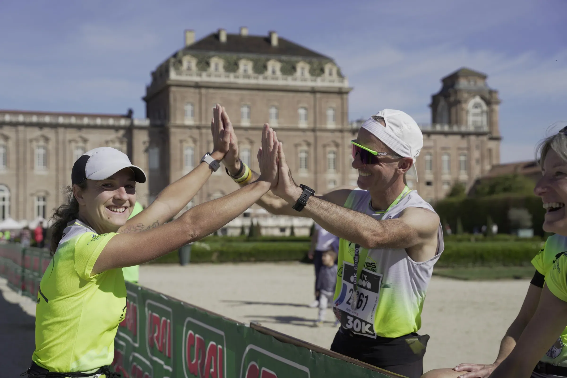 Due runner si battono il cinque dopo la 30 km, davanti alla facciata della Reggia di Venaria