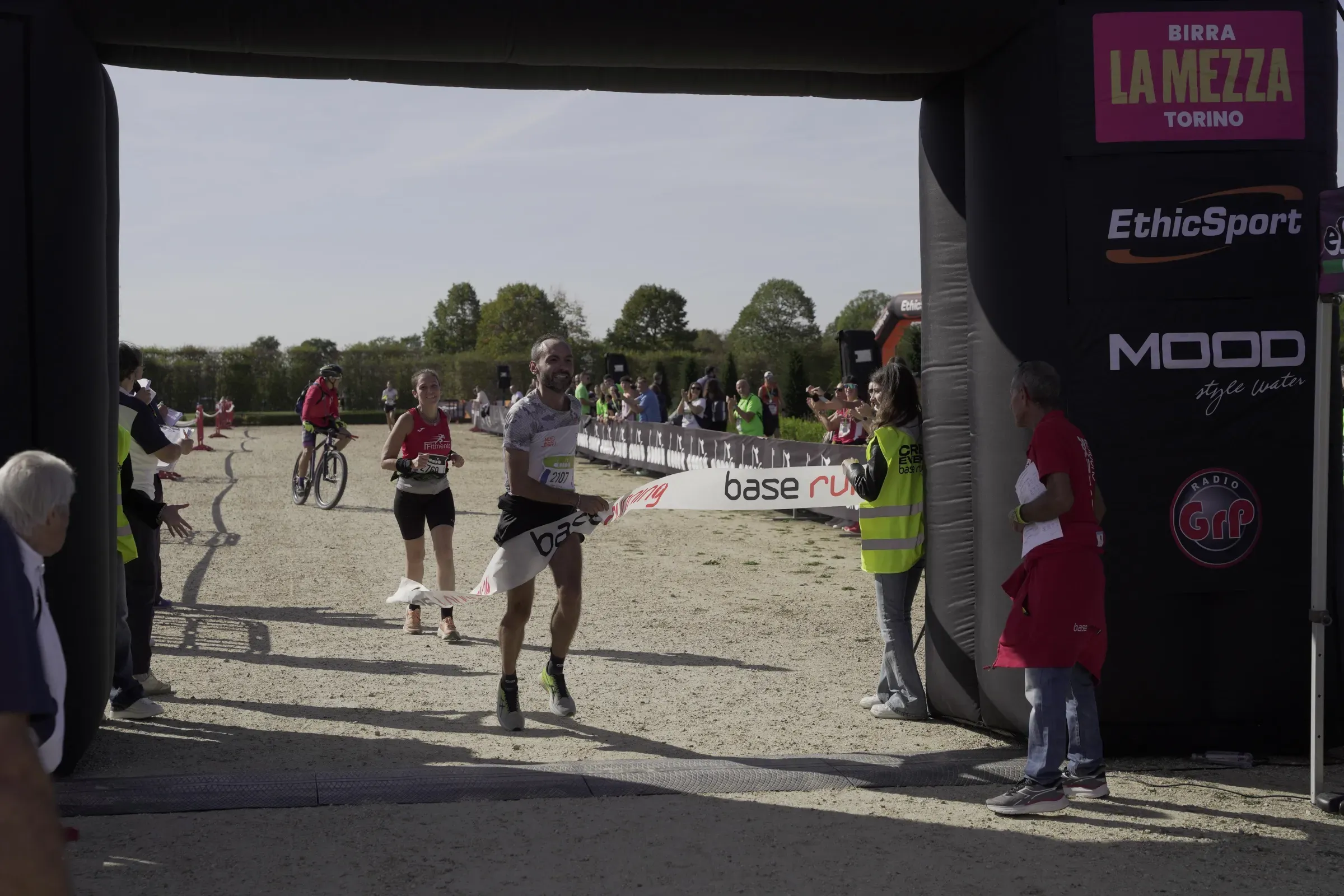 Un runner rompe il nastro Base Running all'arrivo, tra gli applausi lungo le transenne