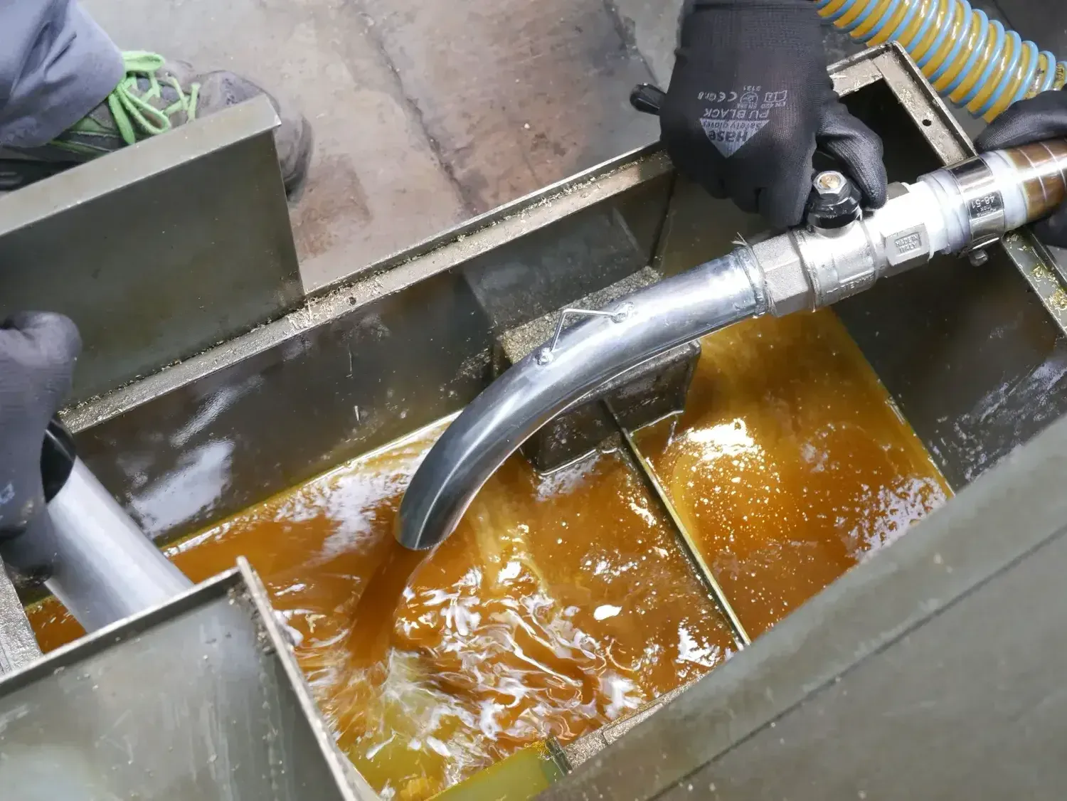 Il tubo di un aspiratore Delfin raccoglie olio e trucioli da una vasca di lavorazione