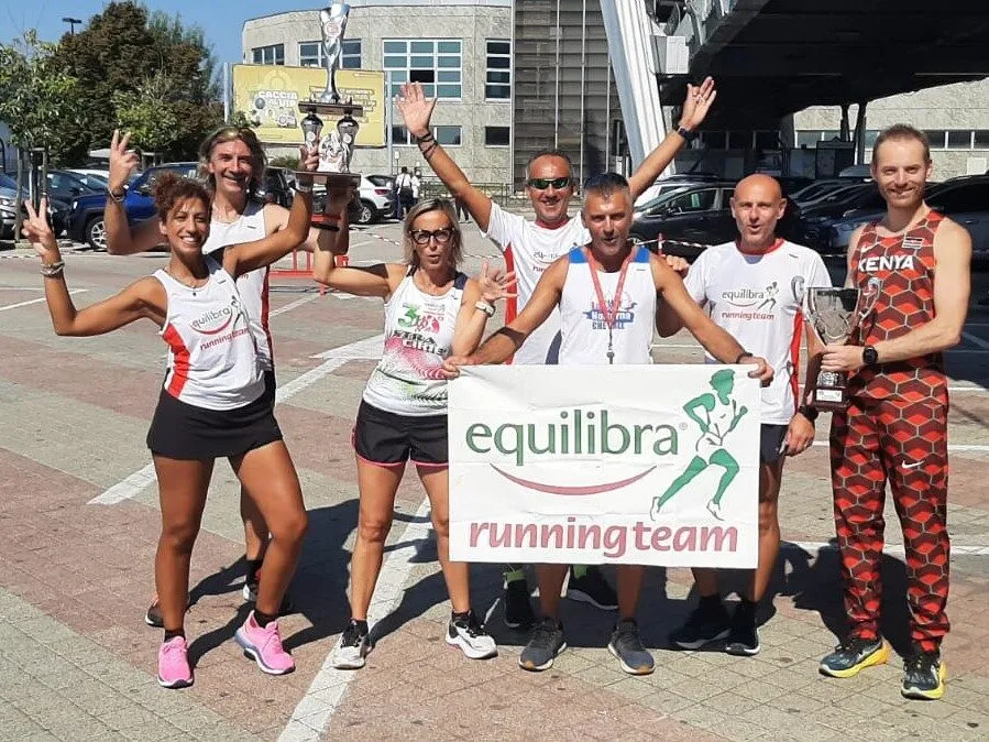 Runner di Equilibra Running Team festeggiano con lo striscione del team
