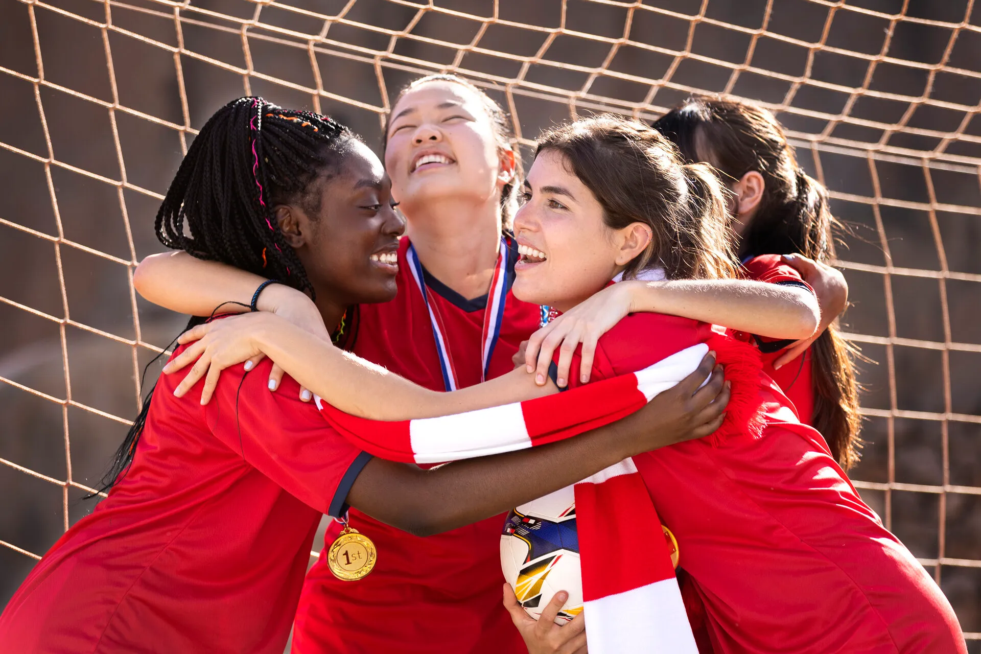 A team celebrates arm in arm with medals round their necks