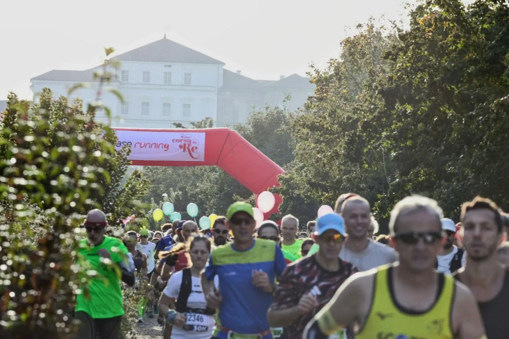 Runner in gara a Venaria Reale, con l'arco rosso Base Running di Una Corsa da Re e la Reggia sullo sfondo