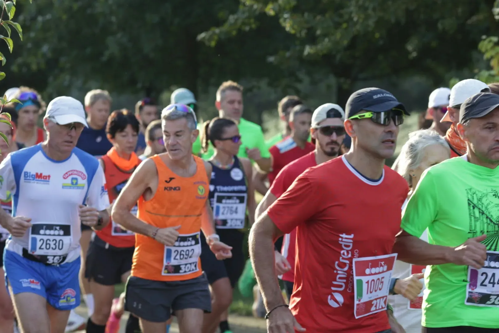 Runner con i pettorali della 30 e della 21 km in gara tra gli alberi del percorso