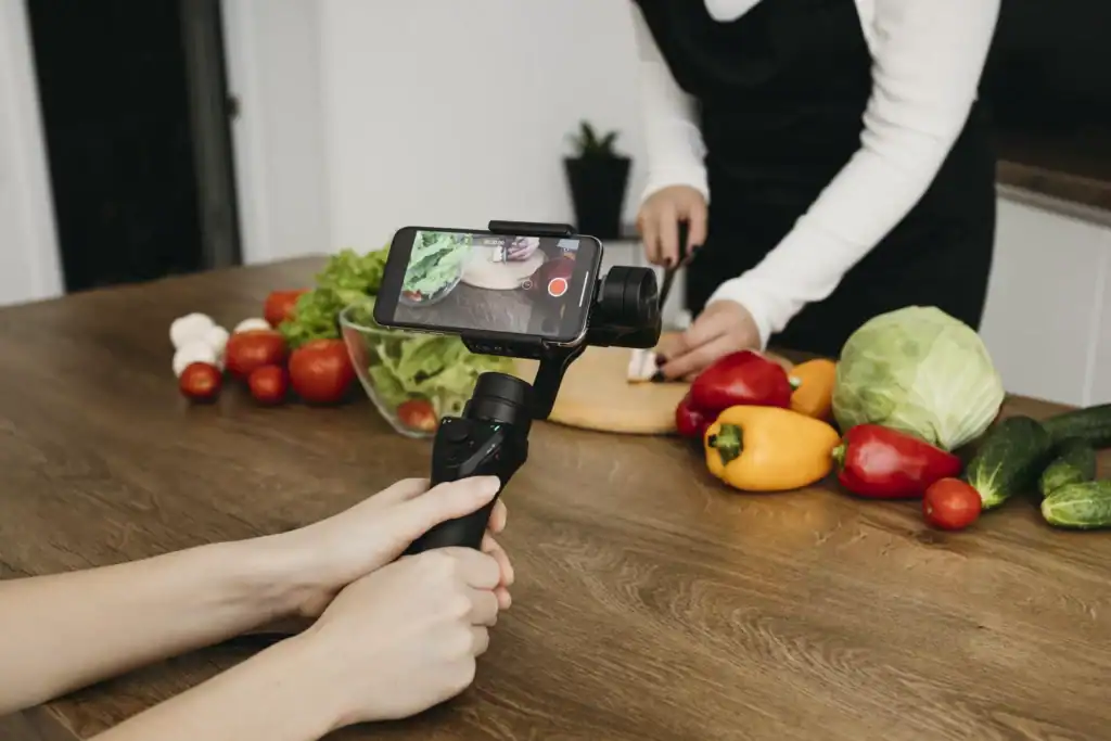 Food Marketing: Come le Aziende Alimentari Vincono Online 1 female blogger recording herself while preparing food